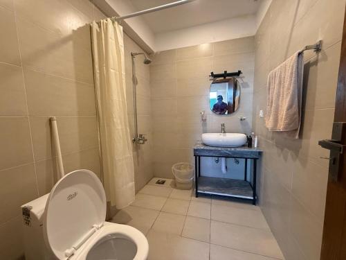 a bathroom with a toilet and a sink and a mirror at Haven Lodge KhairaGali - Pine Ridge Residences #3 in Khaira Gali