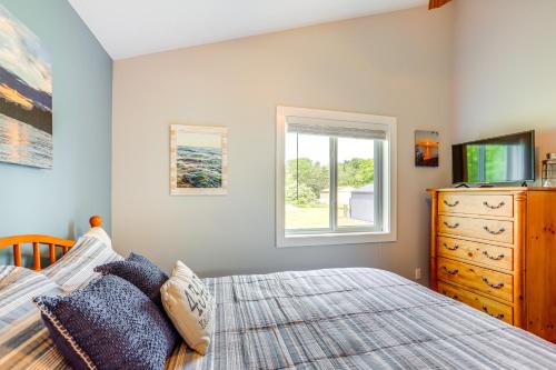 a bedroom with a bed and a television and a dresser at Walk to Lake Kelleys Island Gem with Deck! in Kelleys Island