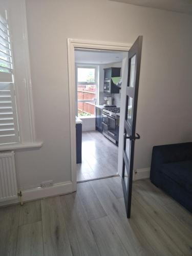 a living room with a door open to a kitchen at Modern 5 bedroom house with parking, London in Thornton Heath