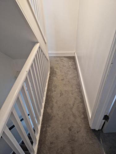 an empty hallway with a stairway leading to a room at Modern 5 bedroom house with parking, London in Thornton Heath