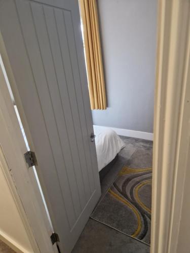a door leading to a bedroom with a bed at Modern 5 bedroom house with parking, London in Thornton Heath