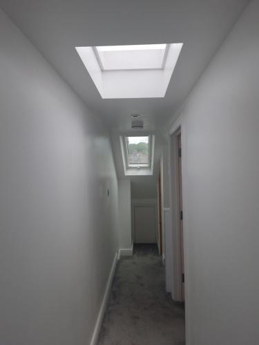 an empty hallway with a skylight in a house at Modern 5 bedroom house with parking, London in Thornton Heath