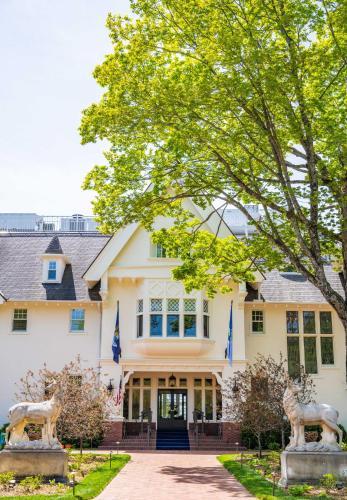 a house with two statues in front of it at The Inn at Stonecliffe in Mackinac Island