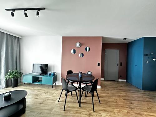 a dining room with a black table and chairs at PURA Vida in Gdynia