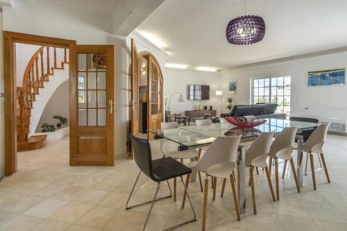 a dining room and living room with a glass table and chairs at LV Premier Algarve FU1- pool, AC, garden, sea view in Moncarapacho