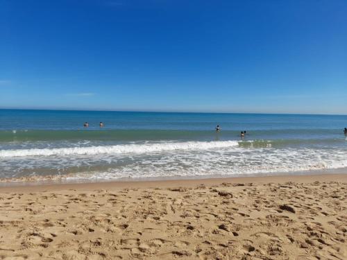 a group of people in the water at the beach at Villa Porto fossa in Marzamemi