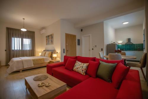 - un salon avec un canapé rouge et un lit dans l'établissement ELEMENT Suites, à Kalambaka