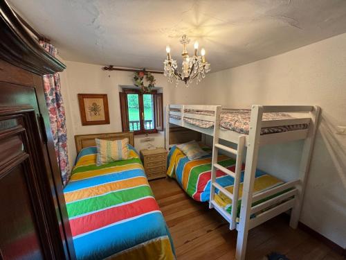 a bedroom with two bunk beds and a chandelier at Casa rural carrales in Matienzo