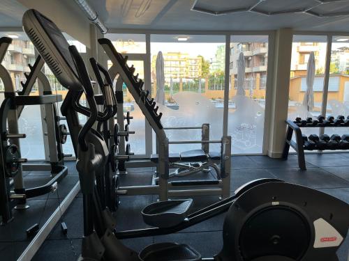 a gym with a row of treadmills and a simulator at Hotel Plamena Palace in Primorsko