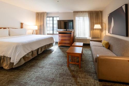 a hotel room with a bed and a couch at Staybridge Suites Houston West - Energy Corridor by IHG in Houston