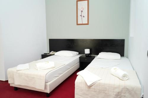 two beds sitting next to each other in a room at Hotel Bliss Aksu in Bucharest