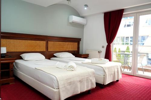 a bedroom with two beds and a balcony at Hotel Bliss Aksu in Bucharest