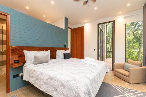 a bedroom with a large bed with a blue wall at Casa de Agua, A Jungle Retreat in Manuel Antonio in Manuel Antonio