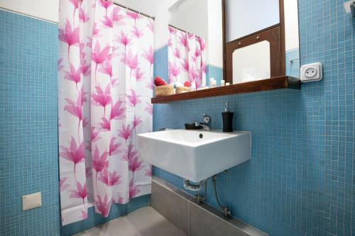 a bathroom with a sink and a shower curtain with pink flowers at LV Premier Apartments Clerigos- RE1 in Porto