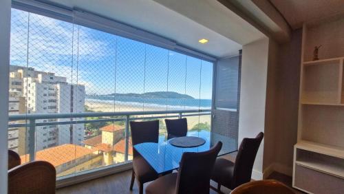una stanza con un tavolo e sedie e una grande finestra di BookSantos Unlimited 905 Duplex com Linda Vista Mar a Santos