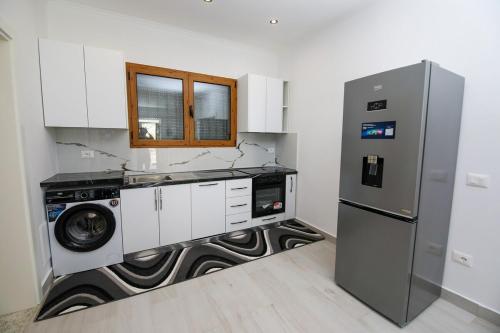 a kitchen with a washing machine and a refrigerator at Era e Liqenit in Shkodër