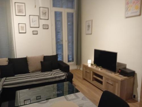 un salon avec un canapé et une télévision à écran plat dans l'établissement Baya en vacances, à Marseille