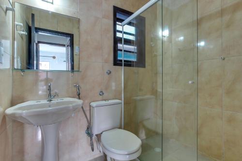 a bathroom with a toilet and a sink and a shower at Residencial Vila do Sol, Apartamentos com pé na areia in Bombinhas