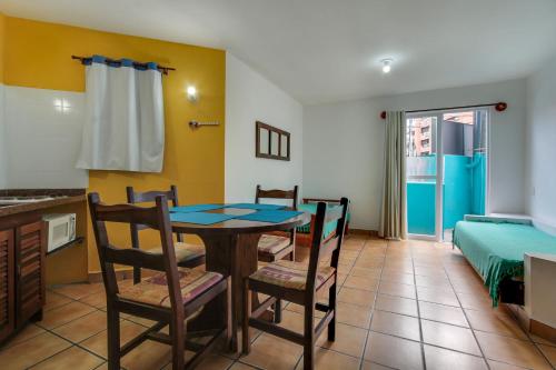 a kitchen and dining room with a table and chairs at Residencial Vila do Sol, Apartamentos com pé na areia in Bombinhas