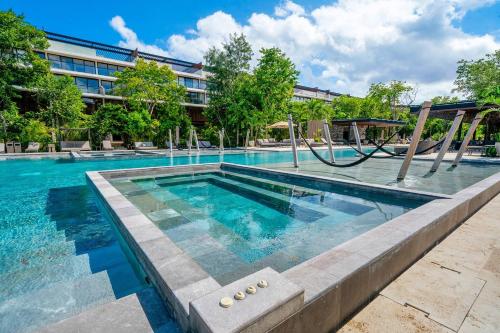 einem Pool mit Rutsche vor einem Gebäude in der Unterkunft Luxury 3 Bedroom Condo - Infinity Pool - AWA Residences - Condo Anahuac 110 in Playa del Carmen