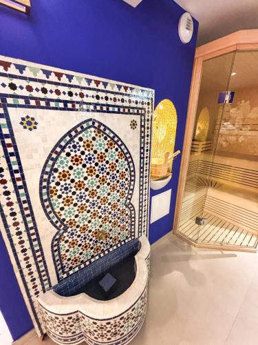 une pièce avec un mur avec une mosaïque d'une porte dans l'établissement La Palmeraie & SPA Privé - Jacuzzi Hammam Sauna, à Mittelhausbergen