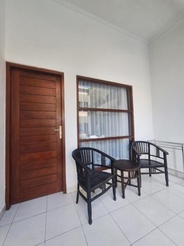 two chairs and a wooden door in a room at Saphala Suites Seminyak in Seminyak