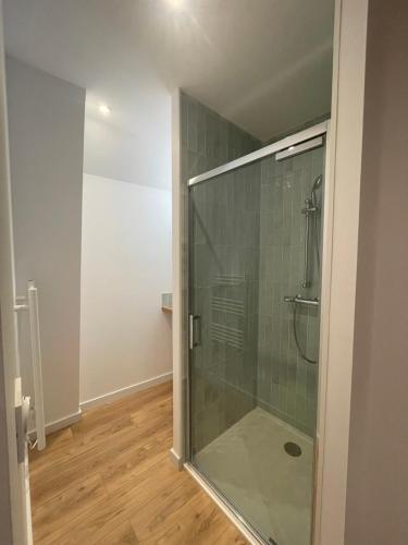 une salle de bain avec une douche avec une porte vitrée dans l'établissement Maison fraîchement rénovée, à Saint-Pierre-de-Plesguen