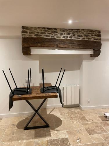 une table avec deux chaises noires et une table en bois dans l'établissement Maison fraîchement rénovée, à Saint-Pierre-de-Plesguen