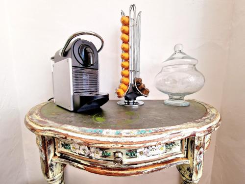 a table with a television and a vase on it at Sweet Rose Guest House Room 3 in Oxford