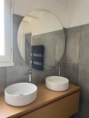 une salle de bain avec un lavabo blanc et un miroir dans l'établissement Villa Oceanside Embassy Surf House, à Seignosse