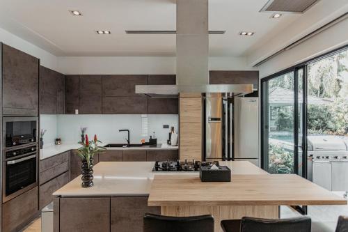 a kitchen with a wooden table and a large window at Tropical Haven 4 Bedroom Pool Villa in Bang Tao Beach