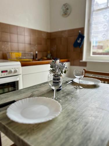 une cuisine avec deux assiettes et des verres sur une table dans l'établissement Petit Kennedy Maison 4 personnes Rochebonne, à Saint-Malo