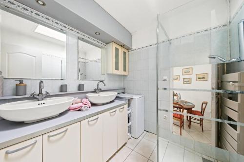 une salle de bain avec deux lavabos et un miroir dans l'établissement Maisonnette au calme et à 3mn du centre de Sanary - climatisée - proche portissol, à Sanary-sur-Mer