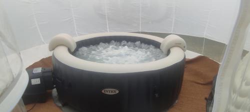 a bath tub filled with water in the corner of a room at La Tiny de Lili in Draveil
