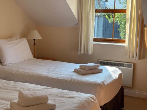 two beds in a room with towels on them at Holiday Home with view of Kenmare Bay Estuary in Kenmare