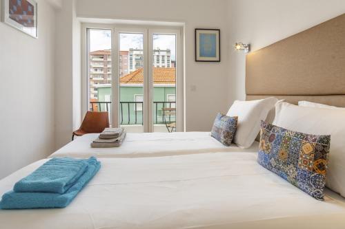 a bedroom with a large white bed with a window at LV Premier Amoreiras AM3 in Lisbon