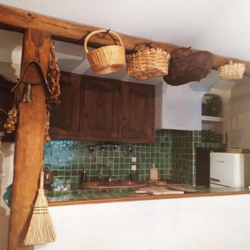 - une cuisine avec des placards en bois et des paniers au plafond dans l'établissement Gîte Naphina, mer à 2.5 km, à La Croix-Valmer