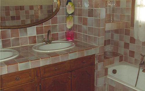 une salle de bain avec deux lavabos, une baignoire et un miroir dans l'établissement Gîte Naphina, mer à 2.5 km, à La Croix-Valmer