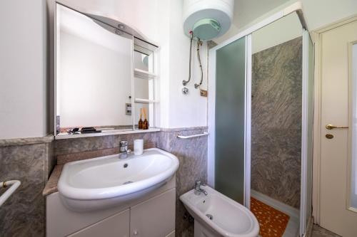 a bathroom with a white sink and a shower at Villa Nonni in Acquaseria