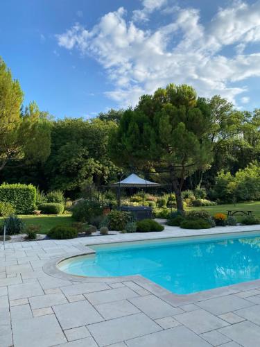 - une piscine dans une cour avec des arbres et un kiosque dans l'établissement Maison de charme - 4 étoiles - Moulin de la serrée, à Nuits-Saint-Georges