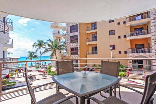 a balcony with a table and chairs and a building at Beachfront Condo, 2 BR - Ocean View at Corto Maltes in Playa del Carmen