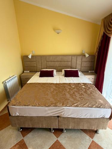 a bedroom with a large bed with two red pillows at Villa Orpheus in Bar