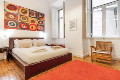 a bedroom with a bed with a painting on the wall at LV Premier Apartments Baixa- CR in Lisbon