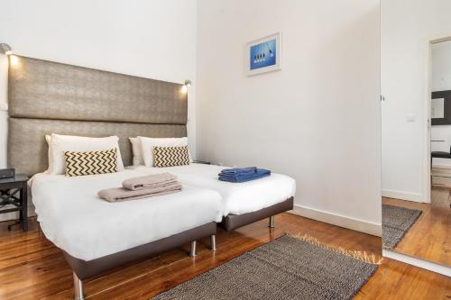 a bedroom with a large white bed with a headboard at LV Premier Apartments Baixa- CR in Lisbon
