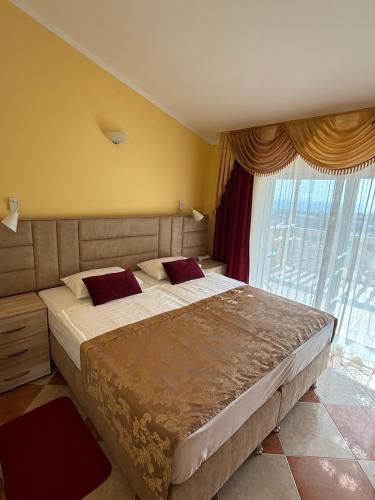 a bedroom with a large bed in front of a window at Villa Orpheus in Bar