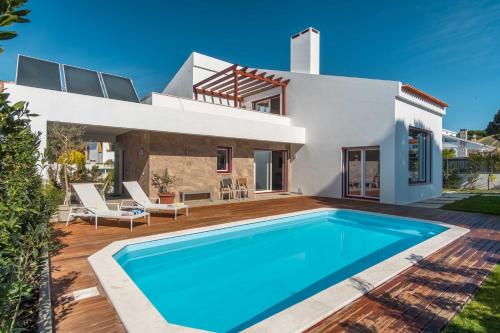 a villa with a swimming pool in front of a house at LV Premier LA2 pool, AC, garden, sea view in Lagoa de Albufeira