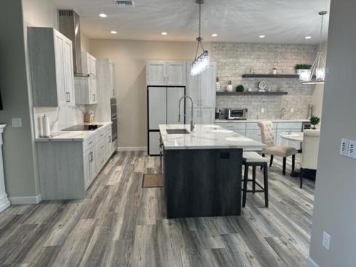 une grande cuisine avec des placards blancs et un grand îlot dans l'établissement Beautiful New construction home - New Pool & Spa!, à Lake Havasu City