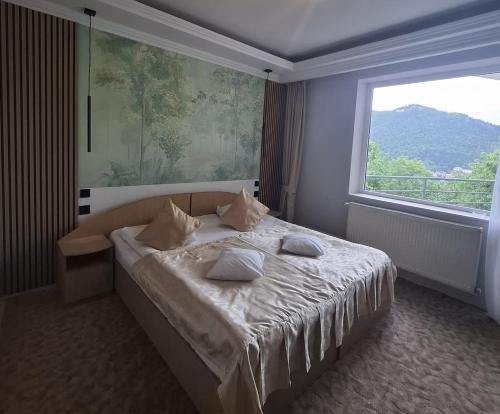 a bedroom with a bed with a large window at Pensiunea Warthe Bed & Breakfast in Braşov