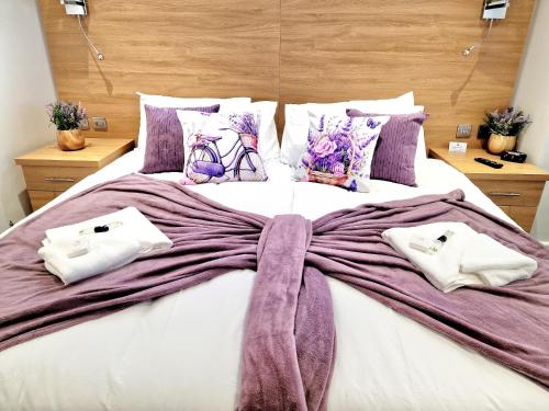 a large bed with a large purple bow on it at Sweet Rose Guest House Room 5 in Oxford