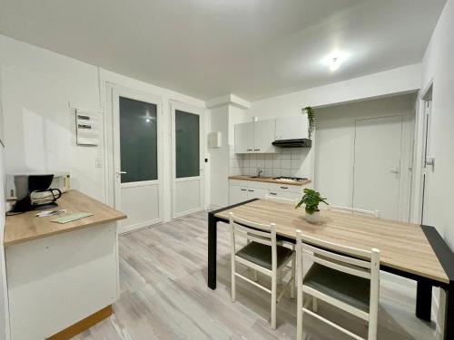 une cuisine et une salle à manger avec une table et des chaises dans l'établissement Appartement T5 avec espace vert, à Cauterets